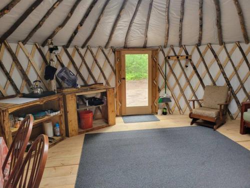 um quarto com uma tenda com uma cadeira e uma porta em Ava Jade Yurt em Brownfield
