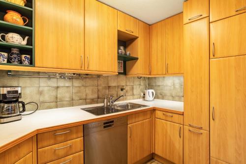 a kitchen with wooden cabinets and a sink at Ferienwohnungen Karle in Künzelsau
