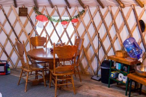 Rufus III Yurt on the river في Brownfield: طاولة وكراسي خشبية في خيمة