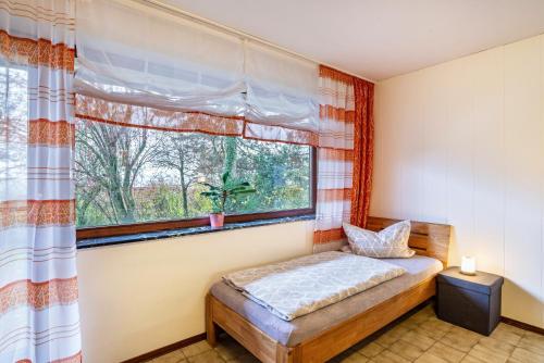 a bedroom with a bed and a window at Ferienwohnungen Karle in Künzelsau