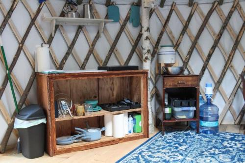 a wooden shelf in a yurt with a table at Allie Mae Yurt nestled in the woods in Brownfield