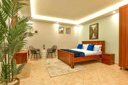 Schlafzimmer mit einem Bett, einem Schreibtisch und Stühlen in der Unterkunft Premier Suites Kyanja in Kampala