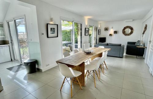 une cuisine et une salle à manger avec une table et des chaises en bois dans l'établissement Domaine de la Pointe de Kerhostin, à Saint-Pierre-Quiberon