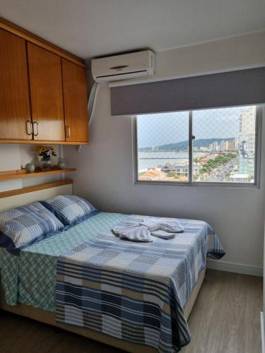 um quarto com uma cama e vista para o oceano em Apartamento Dona Elvira em Piçarras