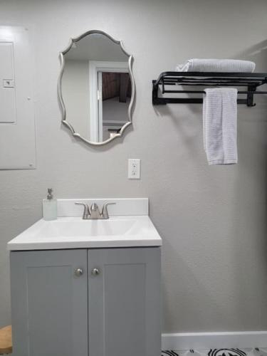 a bathroom with a sink and a mirror on a wall at Little Blue Charming Lakefront in Canadian