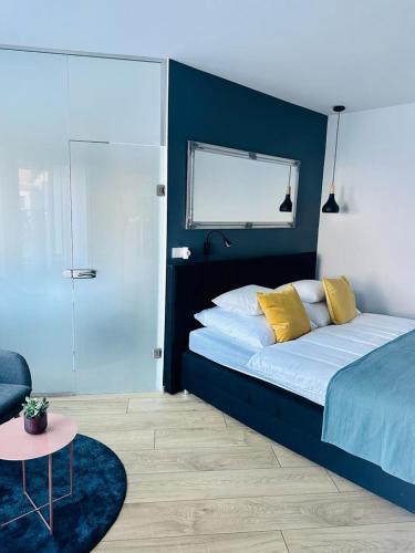 - une chambre avec un grand lit et des oreillers jaunes dans l'établissement Studio apartman, à Kőszeg