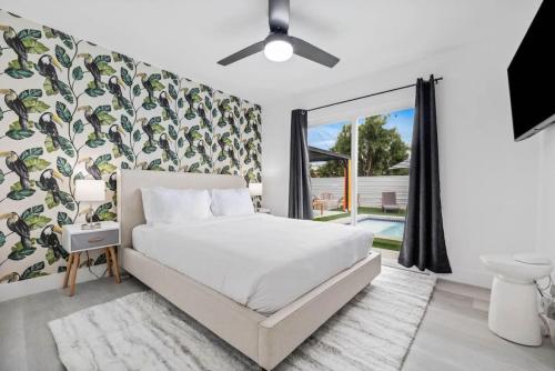 a bedroom with a bed and a large window at NEW Sip Sip Away A Vibrant Pool and Hot Tub Retreat in Palm Springs