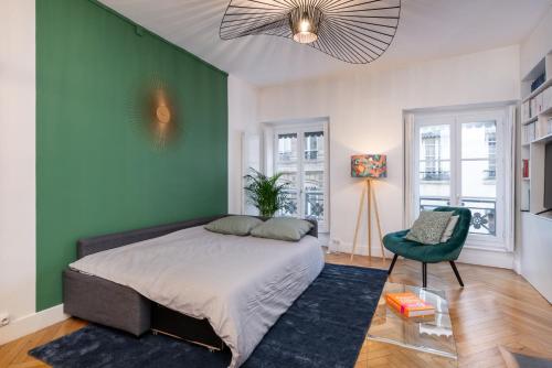 a bedroom with a bed and a green wall at Le Savoir in Lyon