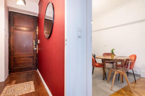 a red wall in a room with a table and a mirror at Le Savoir in Lyon
