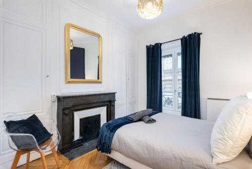 a bedroom with a fireplace and a bed and a mirror at Le Savoir in Lyon
