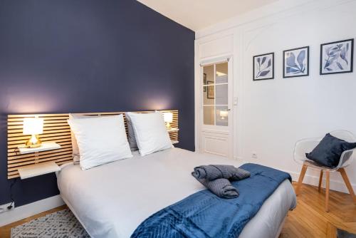 a bedroom with a large bed with a blue wall at Le Savoir in Lyon