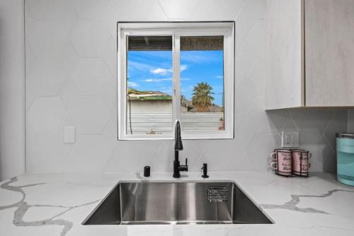 a kitchen with a sink and a window at NEW Sip Sip Away A Vibrant Pool and Hot Tub Retreat in Palm Springs