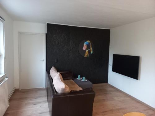 a living room with a couch and a flat screen tv at Top! Appartement Valkenburg in Valkenburg