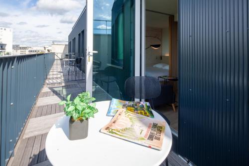 a balcony with a table and a magazine on it at FINESTATE Coliving Mairie d'Issy in Issy-les-Moulineaux