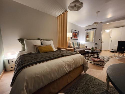 ein Schlafzimmer mit einem großen Bett und ein Wohnzimmer in der Unterkunft Le domaine de Bachmay in Laval