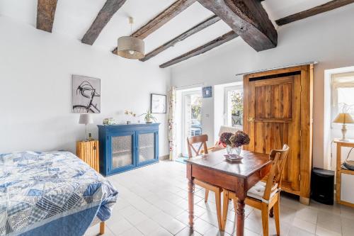une chambre avec un lit, une table et des chaises dans l'établissement Charmante Longère À La Campagne, à Pannecé