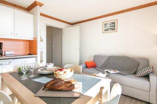 une cuisine et un salon avec une table et un canapé dans l'établissement Résidence Pierre & Vacances Les Bergers, à L'Alpe-d'Huez