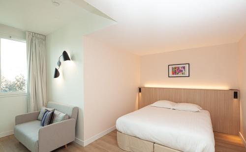 a bedroom with a bed and a chair at FINESTATE Coliving Mairie d'Issy in Issy-les-Moulineaux