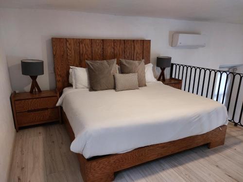 a bedroom with a large white bed with two lamps at Casa Monarcas - Sophia (with AC) in Guadalajara