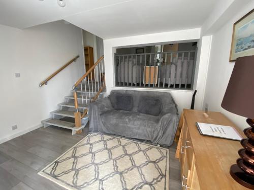 a living room with a couch and a stair case at Beau Vallon Holiday Apartments in St Pierre du Bois