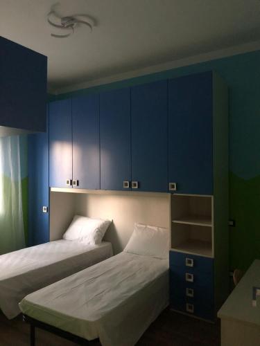 1 dormitorio con 2 camas y armarios azules en Cozy House, en Arezzo