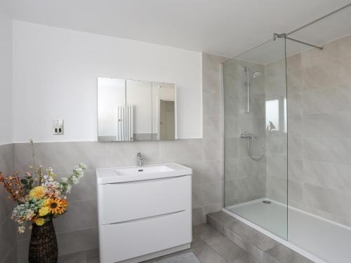 a white bathroom with a sink and a shower at 21 Min Y Mor in Pwllheli