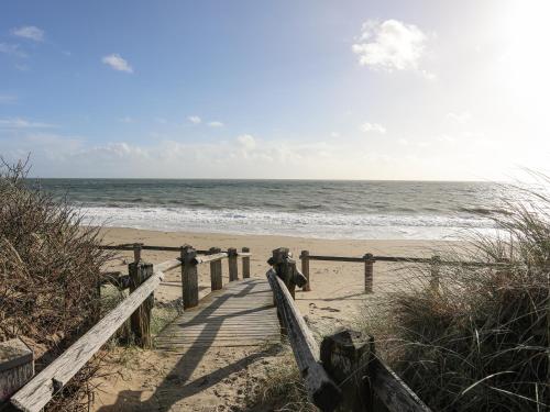 a wooden path to the beach with the ocean at 21 Min Y Mor in Pwllheli
