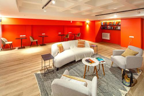 una sala de estar con muebles blancos y paredes rojas. en FINESTATE Coliving Champs-Elysées en París