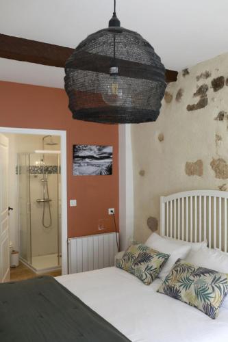 a bedroom with a bed and a shower in a bathroom at Studio - Les Traversières in Eymet