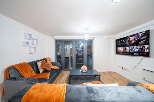 ein Wohnzimmer mit einem Sofa und einem TV in der Unterkunft Spacious 2 Bedroom 6 Minute Drive from Huddersfield Town Centre - Ideal Stay in Huddersfield