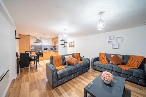 ein Wohnzimmer mit 2 Sofas und einer Küche in der Unterkunft Spacious 2 Bedroom 6 Minute Drive from Huddersfield Town Centre - Ideal Stay in Huddersfield