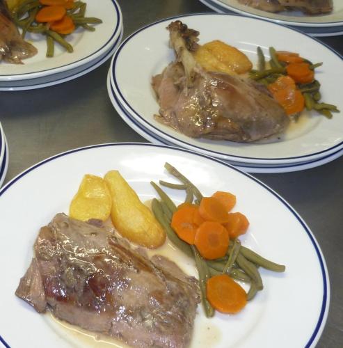 a table with plates of food with meat and vegetables at Chambres d'Hôtes de la Ferme Auberge de Mésauboin in Billé
