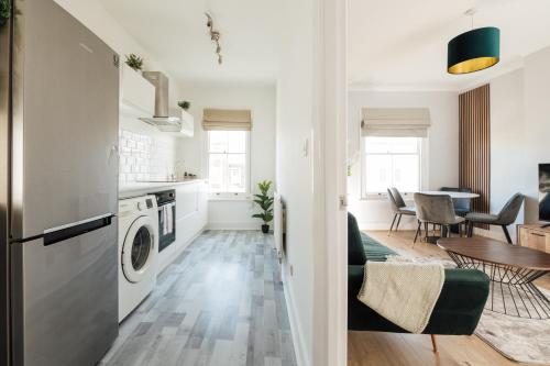 a kitchen and living room with a washer and dryer at Stunning & Stylish 2 Bed Flat in West London l Shepherd's Bush l Acton in London
