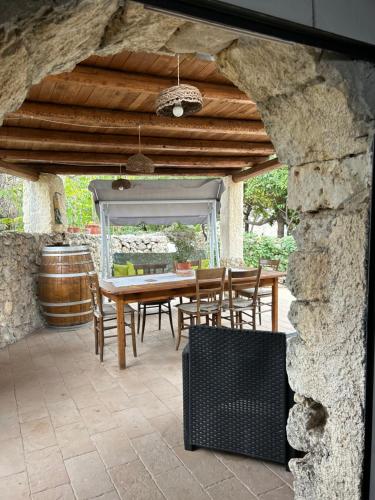 a wooden table and chairs on a stone patio at Antico casale Sofia in Sortino