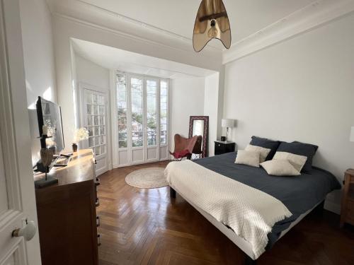 une chambre avec un lit, un bureau et une télévision dans l'établissement Luxueux Appartement 115m2, 3 Chambres centre ville avec parking à 5 min plage -climatisation, à Nice