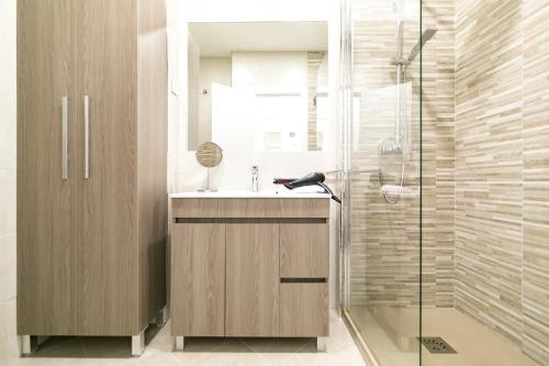 マラガにあるPicasso Premium Apartmentのバスルーム(洗面台、ガラス張りのシャワー付)