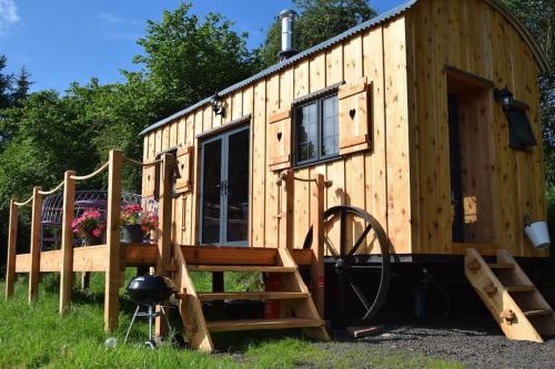 a wooden tiny house with a staircase and a wheel at The Flying Scotsman Shepherd's Hut with Hot Tub in Brecon
