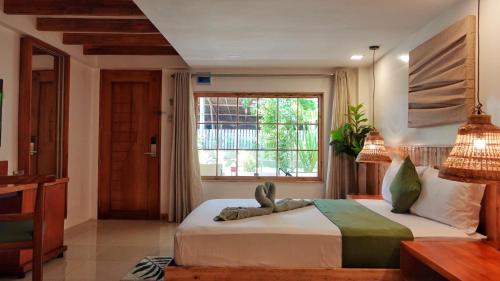 sypialnia z dużym łóżkiem i oknem w obiekcie Senare Boracay Hotel w mieście Boracay