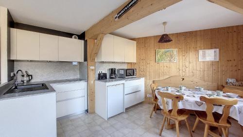 une cuisine et une salle à manger avec une table et des chaises dans l'établissement Grand Cerf 78, à Saint-Jean-dʼAulps