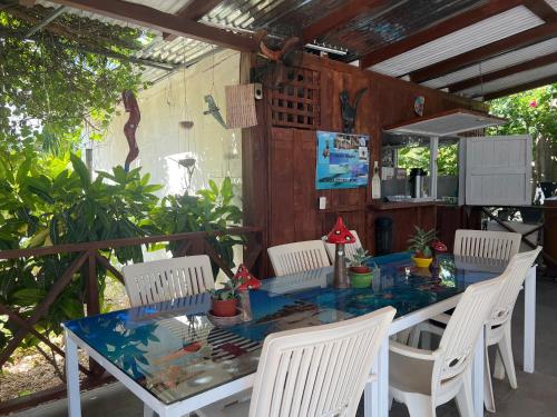 una mesa con sillas blancas, una mesa azul y un sillón en Albergo El Pulpo, Bayahíbe en Bayahibe