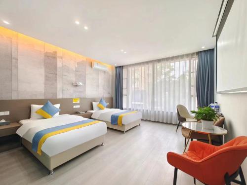 a hotel room with two beds and a chair at Xian Feng Hotel - Tianfu International Airport Branch in Jianyang
