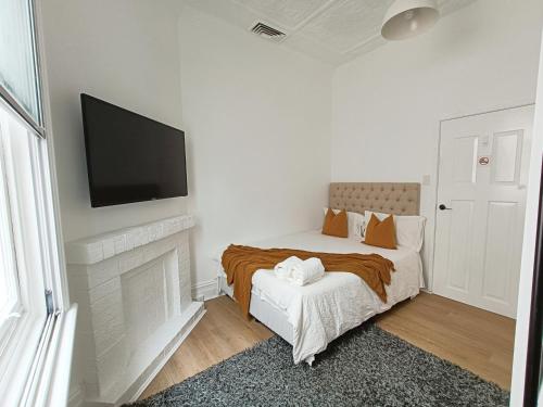 um quarto com uma cama e uma televisão na parede em Stunning Queen Room 1Min Walk to Station with 55 Inch TV em Sydney