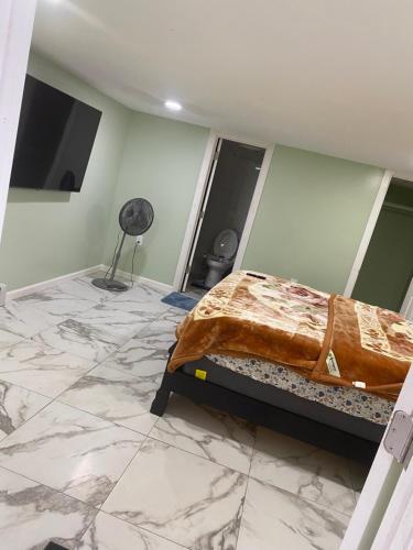 a bedroom with a bed and a marble floor at Single Room in Elmont