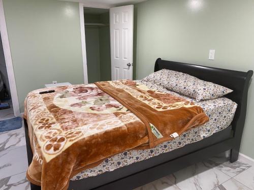 a bed with a blanket on it in a bedroom at Single Room in Elmont