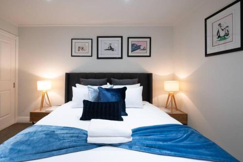 a bedroom with a blue and white bed with two lamps at Gordons Place Entire Apartment CBD Location in Melbourne