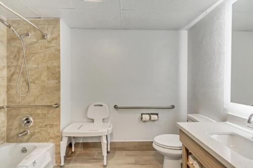 uma casa de banho com um WC, um lavatório e um chuveiro em Suburban Studios Salt Lake City Airport em Salt Lake City