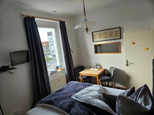 um quarto com uma cama, uma secretária e uma janela em Köln Vermietung Schwermer em Colônia