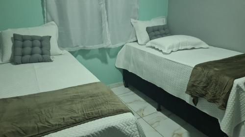 - deux lits assis l'un à côté de l'autre dans une pièce dans l'établissement Flat Recanto da Natureza 02, à Cabo de Santo Agostinho