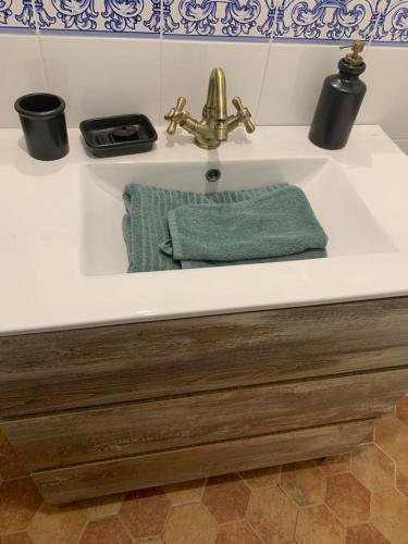 a bathroom sink with a green towel in it at Casa los Laureles in Pilas