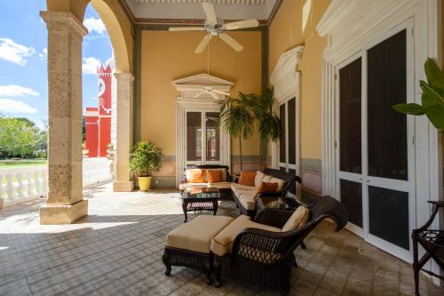 an outdoor patio with chairs and a ceiling fan at Hacienda San Antonio Millet in Tixkokob